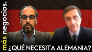 Thumbnail for a news/video: two men in suits on a call, German flag backdrop, caption '¿QUÉ NECESITA ALEMANIA?'.